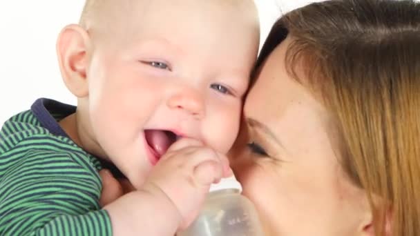 Мама целует своего ребенка, пока он играет. Белый. Закрыть — стоковое видео