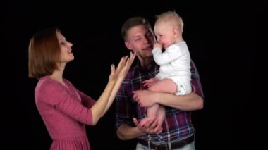 Baba ve anne bebekle oynarken. Siyah