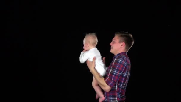 Papá lanza al bebé al aire. Negro — Vídeos de Stock