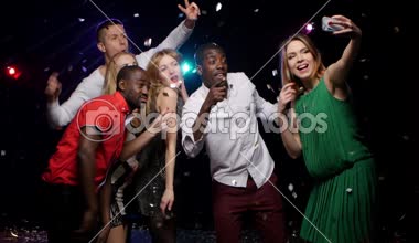 Mono-etnik arkadaşlar dans ve glitter konfeti uçan altında selfie yapmak