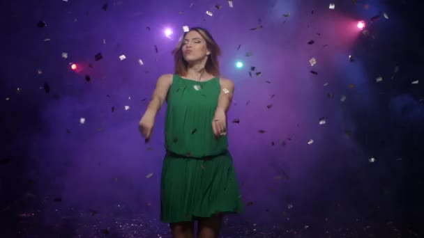 Dansen van de jonge vrouw in groene jurk, onder dalende confetti — Stockvideo