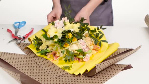 Florist wickelt Papier um Strauß. weiß. Nahaufnahme — Stockvideo