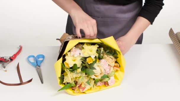 Florist i blomsteraffär. Förbereder för buketter. Vit. På nära håll — Stockvideo