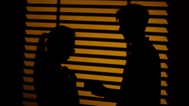 L'uomo fa un regalo a una donna. Un bacio di coppia. Silhouette. Da vicino. — Video Stock