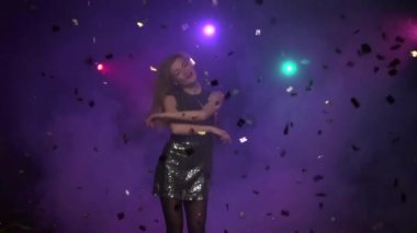 Sarışın kız dans ve glitter konfeti altında döne döne. Ağır çekim