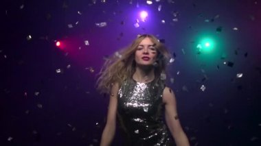 Sarışın kız glitter konfeti altında dans close-up. Ağır çekim