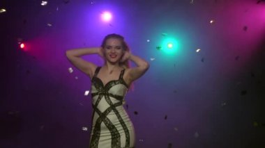 Sarışın kız glitter konfeti altında dans close-up. Ağır çekim