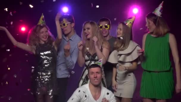 Mädchen und Jungs tanzen auf Partys unter Glitzerkonfetti. Zeitlupe — Stockvideo