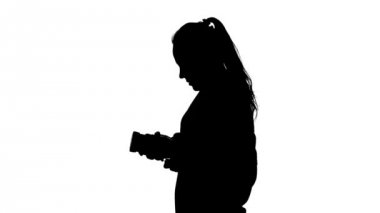 Fotoğrafçı objektife bağlanır ve fotoğraf yapar. Beyaz. Siluet