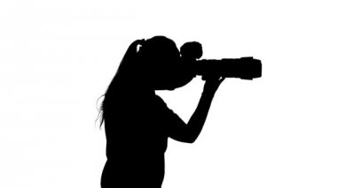 Fotoğrafçı kamera tutuyor ve fotoğraf çekiyor. Beyaz. Siluet