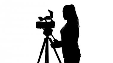 Operatör kamerayı tripoddan çıkarır. Beyaz. Siluet