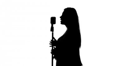 Singer şarkıyı mikrofonla birlikte söyledi. Beyaz. Siluet