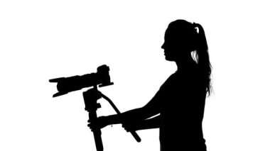 Fotoğrafçı büyük bir lens ile çalışır. Beyaz. Siluet