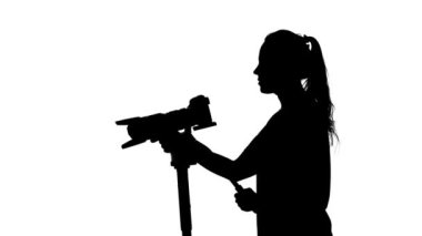 Kameramanların kamera tripod üzerinde tutar. Beyaz. Siluet