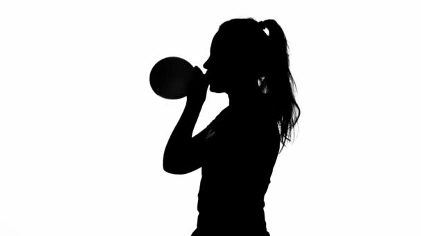 Girl is blowing a balloon. Silhouette. White — Stock Video