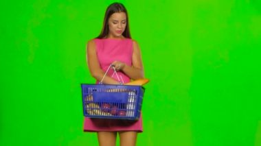 Woman with a basket enjoying the scent of pepper. Green screen