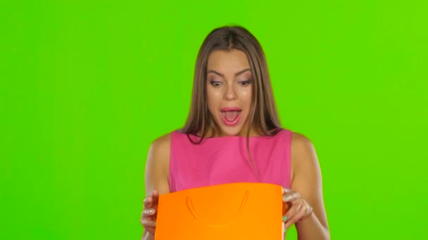 Woman looks at the package and consider buying. Green screen. Close up — Αρχείο Βίντεο