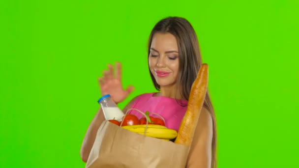 Flickan njuter av doften av produkterna. Grön skärm. Närbild — Stockvideo