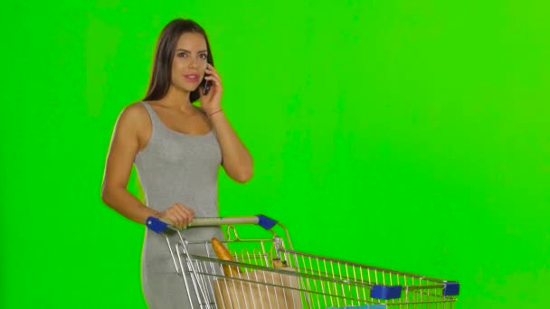 Woman made the purchase and calls on mobile. Green screen — Stock video