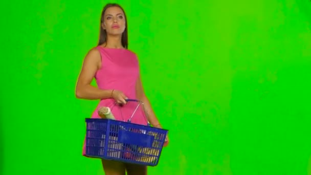 Woman with shopping basket choosing products. Green screen — Wideo stockowe