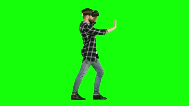 Ο άνθρωπος σε μια μάσκα εικονικής πραγματικότητας περπατάει. Πράσινη οθόνη — Αρχείο Βίντεο