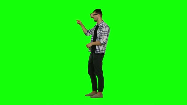 Hombre con gafas de realidad virtual. Usando gestos con las manos. Pantalla verde — Vídeo de stock