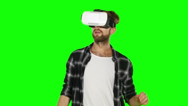 Hombre en una máscara de realidad virtual mira a su alrededor. Pantalla verde. De cerca. — Vídeo de stock