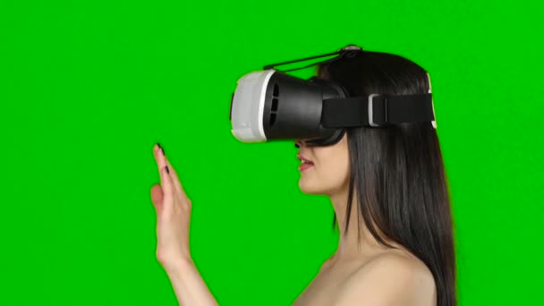 Juego de realidad virtual. Chica con sorpresa y placer utiliza pantalla montada en la cabeza. Pantalla verde. De cerca. — Vídeos de Stock