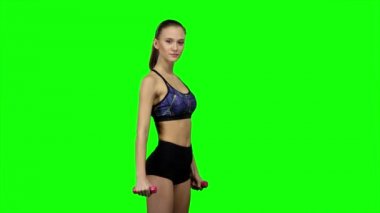 Woman fitness instructor doing exercises. Green screen