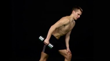 Adam kendi figürü üzerinde çalışır. Fitness için ağırlıklar. Siyah