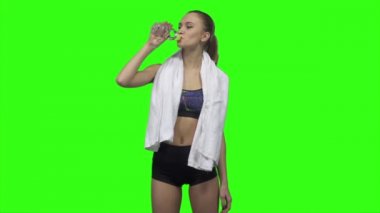 Woman is drinking water and towels. Slow motion. Green screen