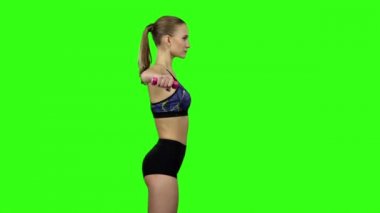 Woman with dumbbells in profile. Slow motion. Green screen