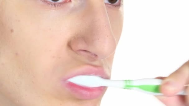 Muž stojící v profilu, čistí zuby. Bílé pozadí. Detail — Stock video