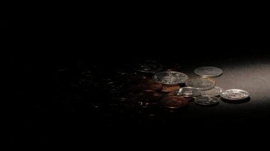 Karanlık bir yüzey üzerinde paralar. Spot ışık