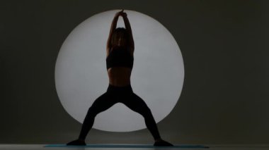 Spor hocası bir ağız kavgası yapıyor. Sportif kadın. Arka ışık. Siluet