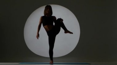 Atlet dikey uzanan yapıyor. Arka ışık. Siluet