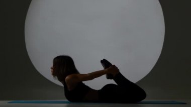 Kadın poz mide esneme yapmaz. Arka ışık. Siluet