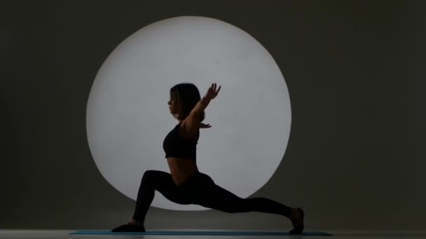 Woman doing stretching. Sports exercise. Back light. Silhouette — Stock Video