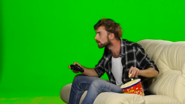 Man is freaking out and spilled popcorn on the couch. Green screen — Stock Video