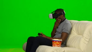 Adam bir joystick ile Vr maskeli oyunu oynar. Yeşil ekran