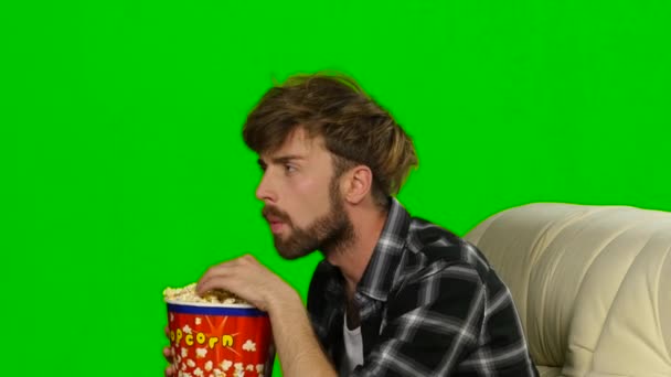 Guy emotional watching a movie and eating popcorn. Green screen — Stock Video