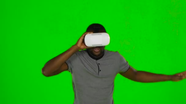 Man houdt een masker van virtual reality op zijn hoofd. Groen scherm — Stockvideo