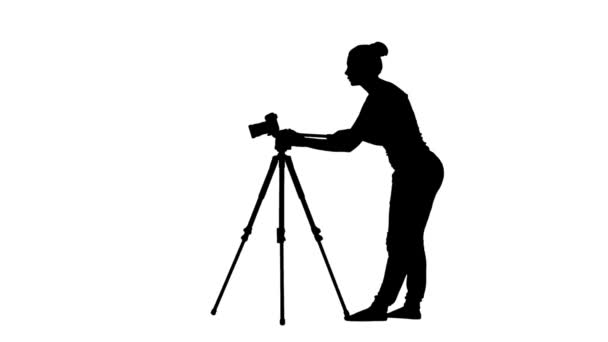 Operator works with the camera on a tripod. Silhouette. White — Stock Video