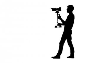 Operatör kendi etrafında dönerek çekim yapar. Siluet. Beyaz arka plan