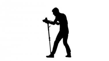 İşleci ile kamera tripod üzerinde çalışır. Siluet. Beyaz