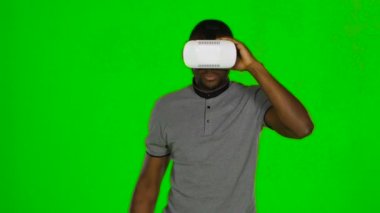 Adam odada dolaşır ve Vr maskesini elleriyle tutar. Yeşil ekran