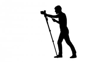 Kamerayı tripod üzerinde operatörün etrafında döndürme. Siluet. Beyaz