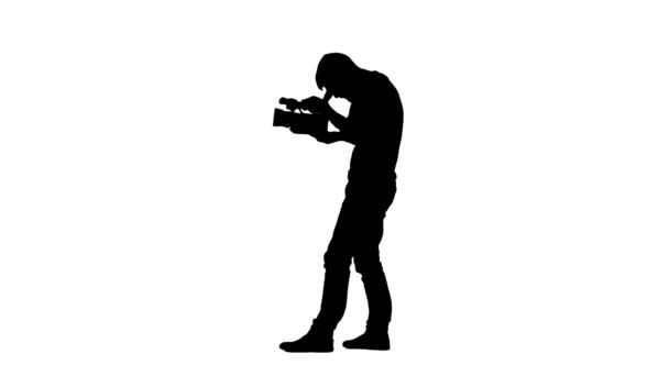 Holding the camera in hands of operator makes videotaping. Silhouette — Stock Video