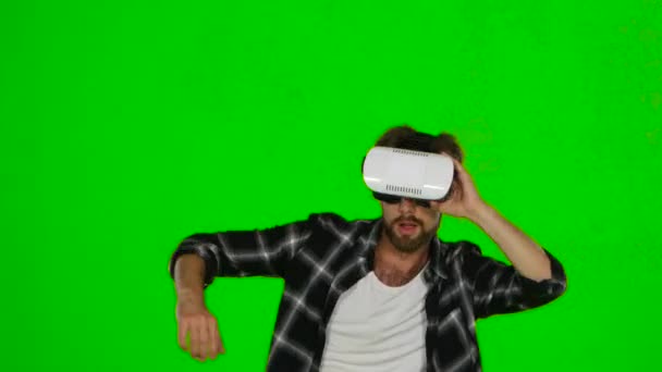 El hombre camina por la habitación con una máscara de realidad virtual. Pantalla verde — Vídeo de stock