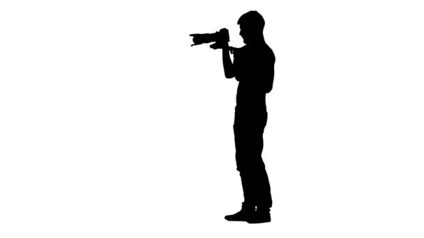 Man makes videotaping, turning around itself. Silhouette. White background — Stock Video